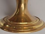 a close up of a gold vase on a table
