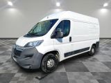 la camionnette blanche est garée sur un sol carrelé en damier