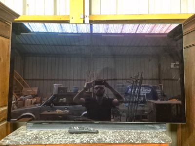 un homme en train de se prendre en photo dans le miroir d'un téléviseur à écran plat