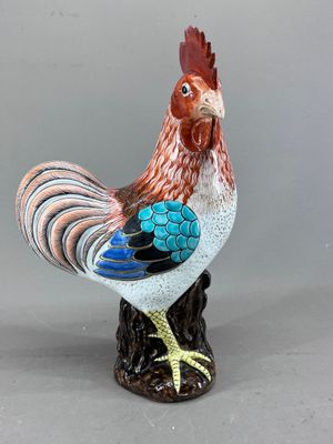 une figurine représentant un coq debout sur une souche d'arbre