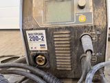 a soldering machine sitting on the ground next to a garage door