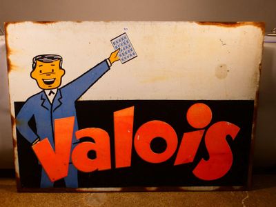 une enseigne sur laquelle on peut lire « Vallo's » avec un homme en costume