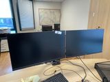 a desk with two monitors and a laptop on it