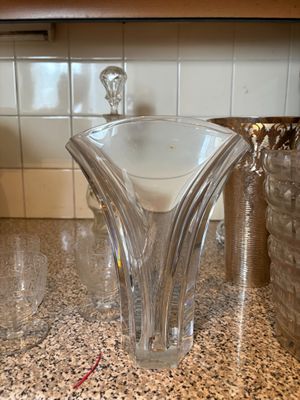 un vase en verre posé sur un plan de travail, à côté d'autres vases en verre