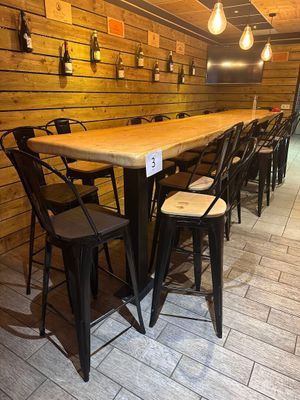 Des tables et des chaises sont alignées dans une pièce aux murs lambrissés.