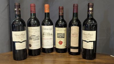 six bottles of wine are lined up on a wooden table