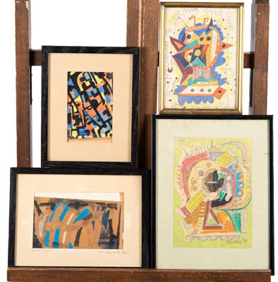 several framed art pieces are displayed on a shelf in front of a white background