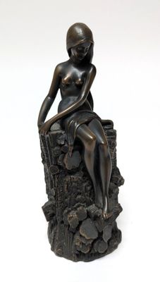 statue of a woman sitting on a tree stump with her hands on her knees