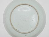 a white plate with a brown rim sitting on a table