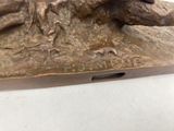 a bronze statue of a dog laying on a rock