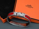 une boîte orange contenant un bracelet en argent et une boîte noire avec un fermoir en argent