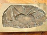 un objet métallique posé sur un parquet et ayant la forme d'une fleur