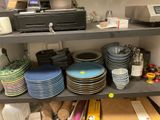 de nombreuses assiettes et bols sur une étagère dans un magasin