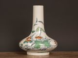 un vase blanc orné d'un motif floral, posé sur une table