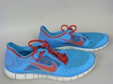 une paire de chaussures de course Nike bleues et rouges posées sur une surface blanche