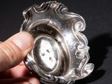 a person holding a silver ashtray in their hand