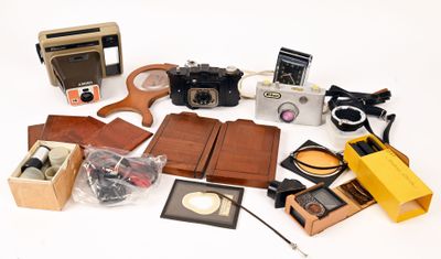 many different types of cameras and accessories on the table