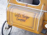 a small yellow truck with a sign on the side of it
