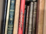 a box full of old books sitting on a shelf