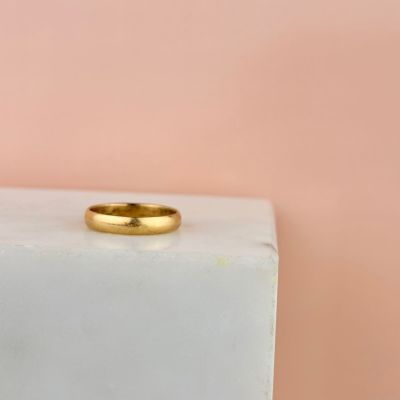 une alliance en or posée sur un bloc de marbre