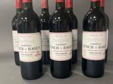 six bouteilles de vin sont alignées sur une table