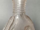 a clear glass bottle with a bird on it