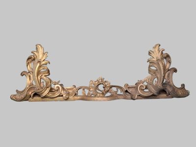 an image of a pair of ornate brass brackets on a gray background