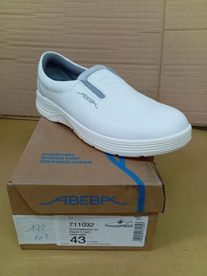 men ' s white slip on shoes in a box on a table