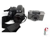 a black camera and a silver camera on a white background