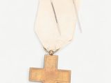 an image of a gold medal with a cross on a white background