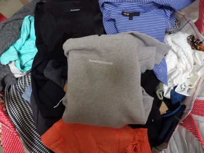 a pile of clothes in a suitcase on a bed