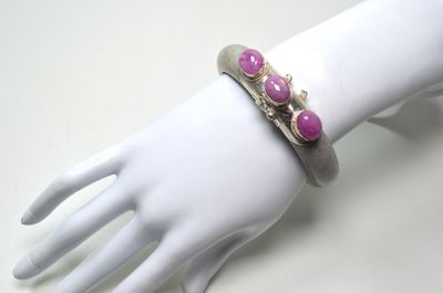 bracelet posé sur la main d'un mannequin, orné de pierres roses
