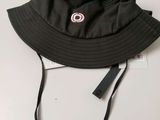 a close up of a black hat on a white surface