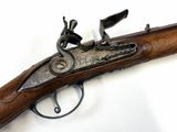 an old gun that is on display on a white surface