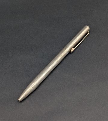 un stylo argenté posé sur une surface noire