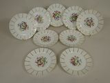 six white plates with floral designs are arranged on a white surface