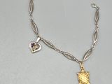 un gros plan sur un bracelet en argent orné d'une breloque dorée et violette