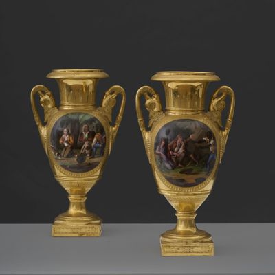 pair of gold vases with a painting of a scene on them