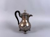 une cafetière ancienne en argent avec une poignée noire sur fond blanc