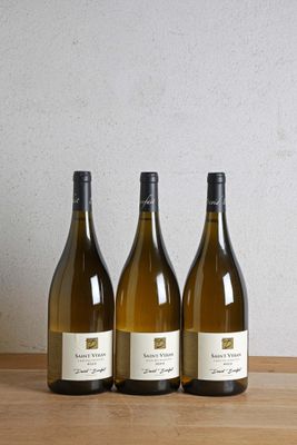 trois bouteilles de vin posées sur une table en bois