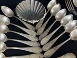 a lot of silver spoons and forks on the table