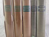 quatre vieux livres sont alignés sur une surface blanche