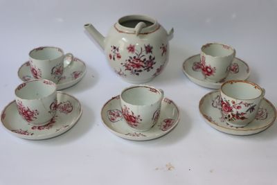 cinq tasses et soucoupes ainsi qu'une théière sur la table