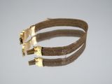 a close up of a gold bracelet with two metal clasps