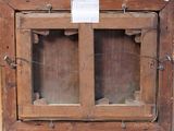 an old wooden cabinet with a glass door and a sign on it