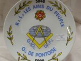 une assiette ornée d'un emblème maçonnique, posée sur une table