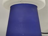 a blue and white lamp that is on a white table