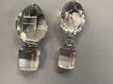 two clear glass knobs on a white surface