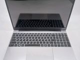 a silver laptop with a black keyboard on a white table