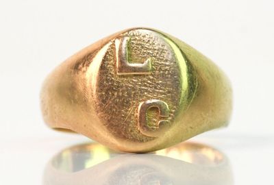 une image d'un gros plan d'une bague en or sur une surface blanche